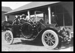 Automobile and passengers outside McMynn's store and post office